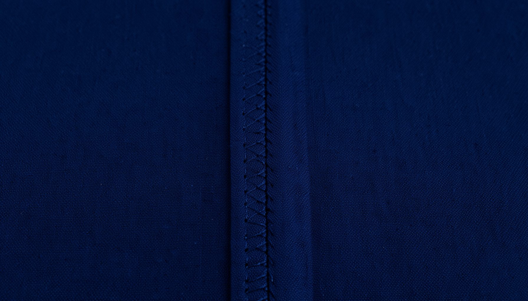 Close-up of dark navy fabric seam with zigzag stitching detail